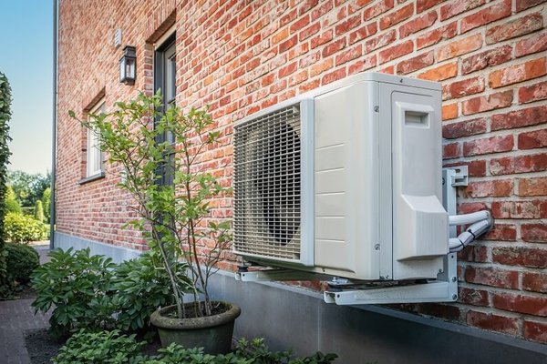 Air source heat pump outdoor unit on brick building